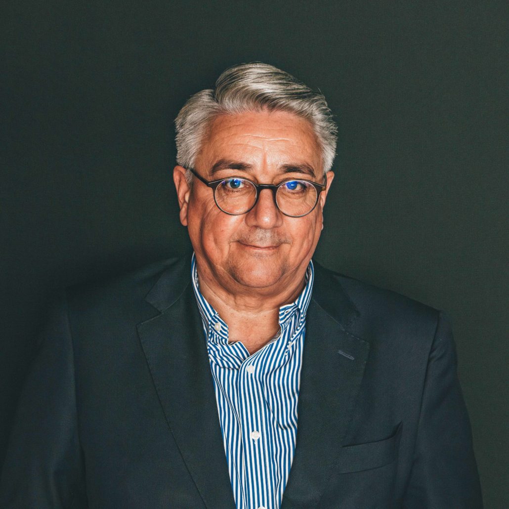 Matthias Steinbach Porträtfoto von Matthias Steinbach, einem älteren Mann mit Brille und grauen Haaren, der in die Kamera blickt. Er trägt ein dunkelblaues Sakko über einem blau-weiß gestreiften Hemd. Der Hintergrund ist dunkel.